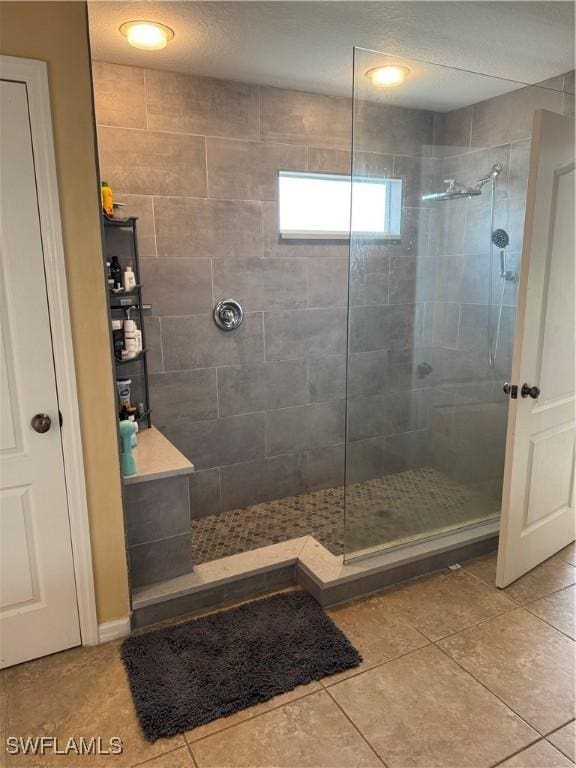 bathroom with a tile shower and tile patterned floors