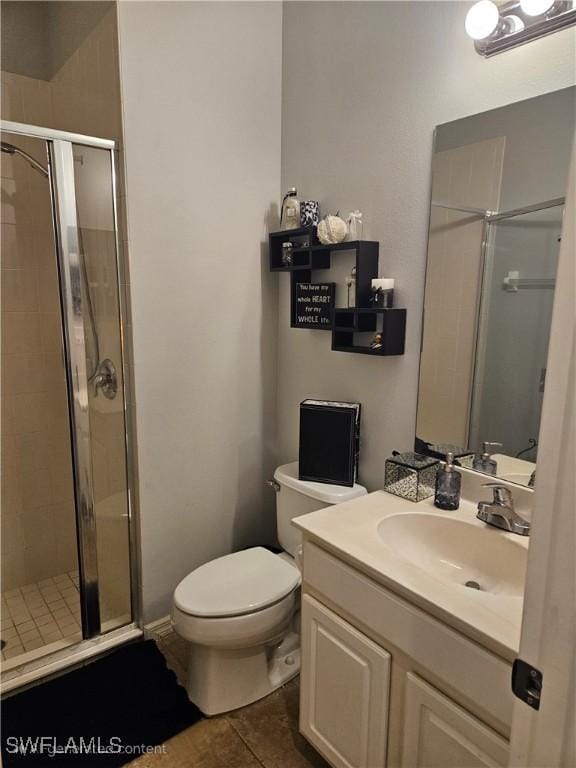 bathroom with tile patterned floors, vanity, toilet, and a shower with shower door