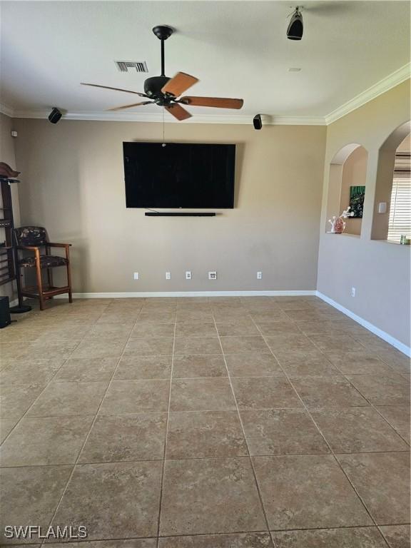 unfurnished living room featuring baseboards, visible vents, arched walkways, and crown molding