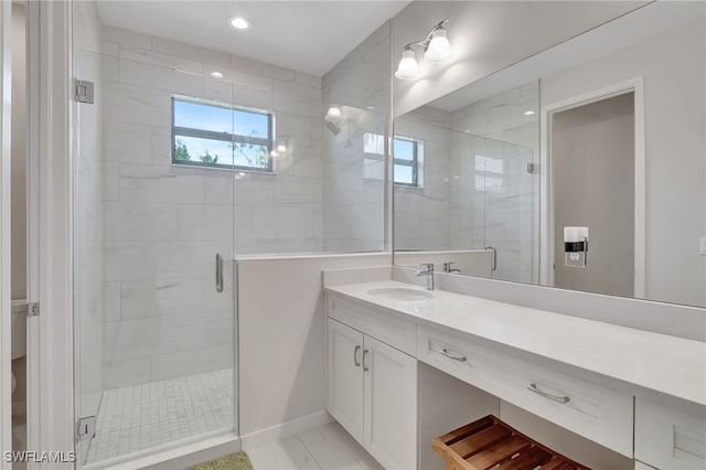 bathroom featuring tile patterned flooring, vanity, and a shower with door