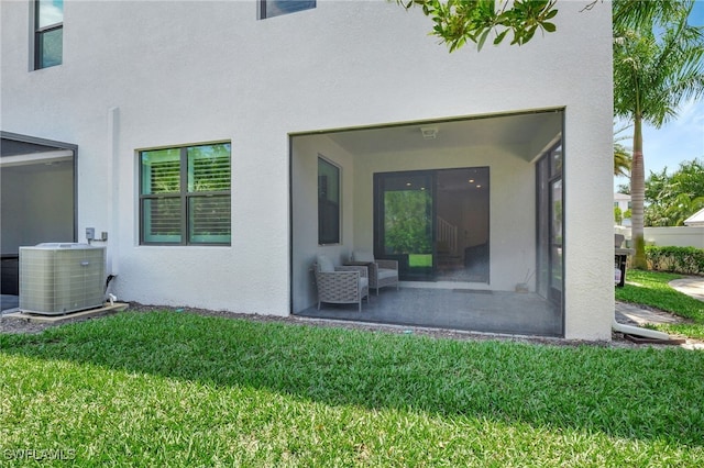 rear view of property with a yard and central AC