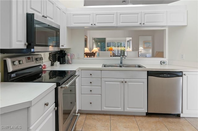 kitchen with light tile patterned floors, stainless steel appliances, white cabinetry, and sink