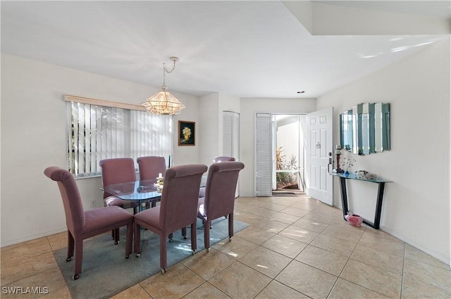 dining room with light tile patterned floors and an inviting chandelier