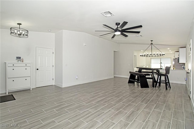 living room with ceiling fan with notable chandelier