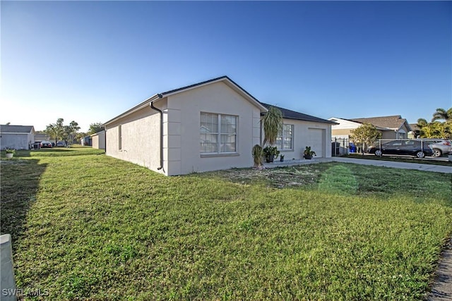 view of side of home with a garage and a lawn