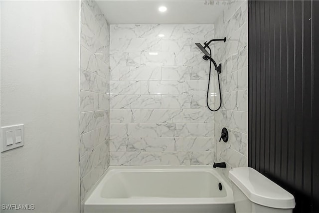 bathroom with toilet and tiled shower / bath combo