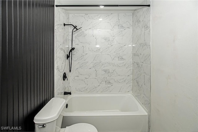 bathroom with tiled shower / bath combo and toilet