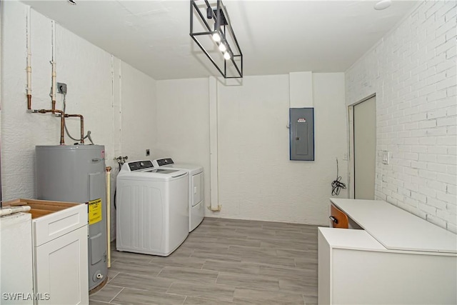 laundry room with brick wall, electric water heater, electric panel, and independent washer and dryer