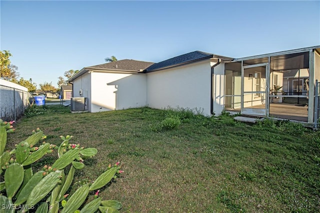 view of yard featuring a sunroom and central air condition unit