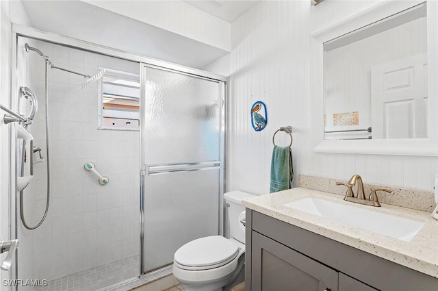 bathroom featuring vanity, toilet, and a shower with shower door