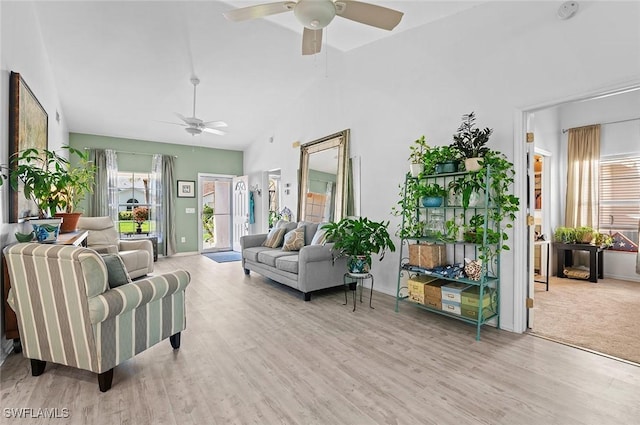 living room featuring ceiling fan, high vaulted ceiling, and light hardwood / wood-style flooring