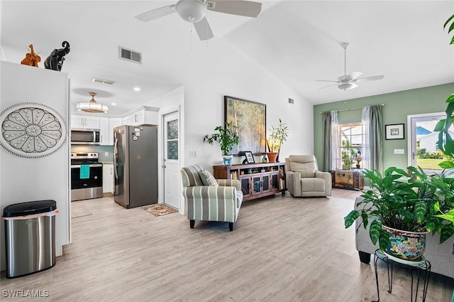 living room with ceiling fan, lofted ceiling, and light wood-type flooring