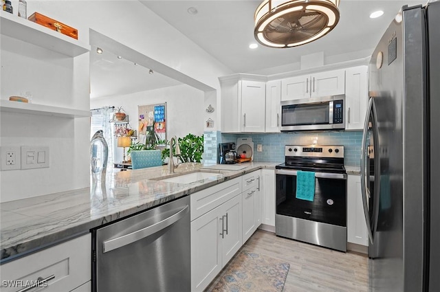 kitchen featuring kitchen peninsula, stainless steel appliances, white cabinetry, and sink