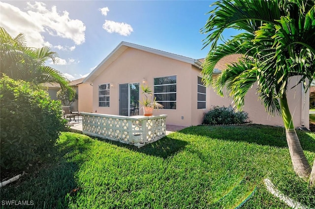 rear view of property featuring a lawn