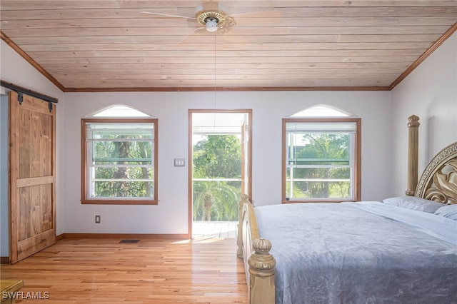 unfurnished bedroom with ceiling fan, a barn door, light hardwood / wood-style flooring, wooden ceiling, and lofted ceiling