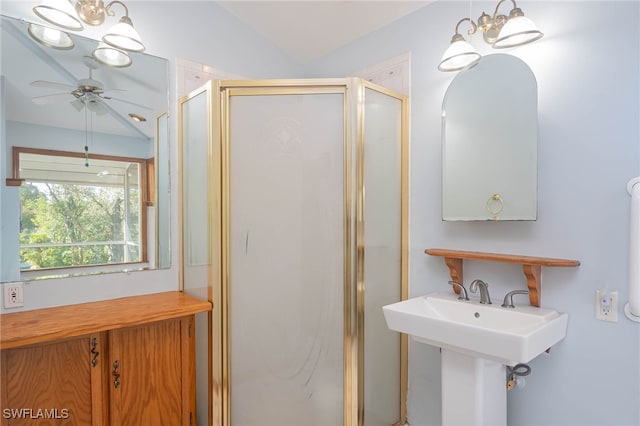 bathroom featuring ceiling fan with notable chandelier, a shower with shower door, sink, and vaulted ceiling