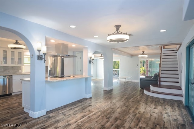 kitchen featuring white cabinetry, dark hardwood / wood-style floors, island exhaust hood, decorative light fixtures, and appliances with stainless steel finishes