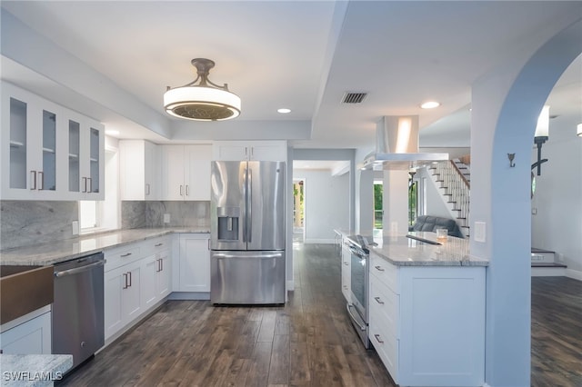 kitchen with light stone countertops, appliances with stainless steel finishes, backsplash, dark hardwood / wood-style flooring, and white cabinetry