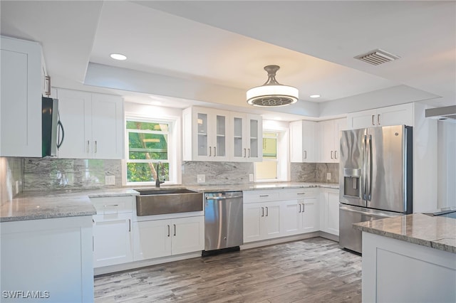 kitchen featuring white cabinetry, stainless steel appliances, and light stone counters