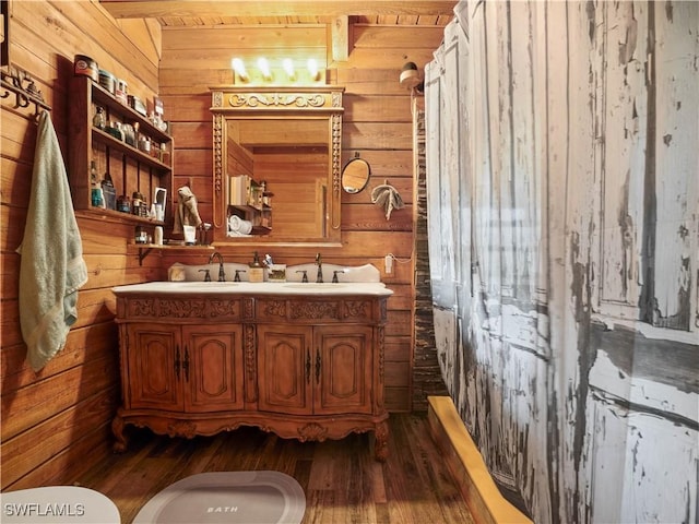 bathroom featuring hardwood / wood-style floors, vanity, and wooden walls