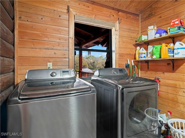 laundry area with wooden walls, washer and clothes dryer, and wood ceiling