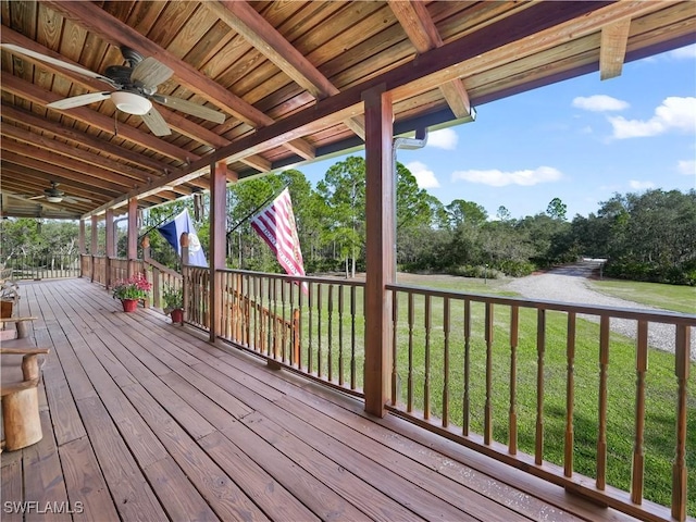 wooden deck featuring a lawn and ceiling fan