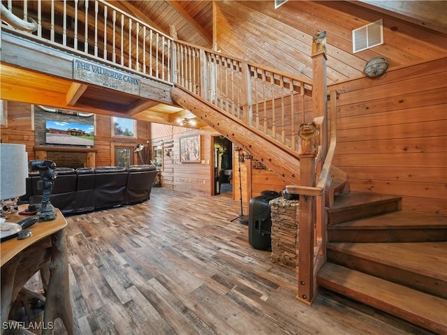 living room featuring wooden walls, hardwood / wood-style floors, high vaulted ceiling, and wooden ceiling