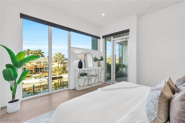 bedroom with access to exterior and wood-type flooring