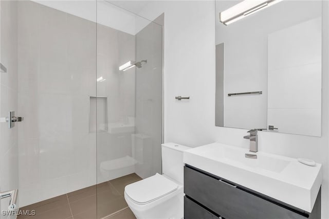 bathroom featuring tile patterned floors, vanity, toilet, and a shower