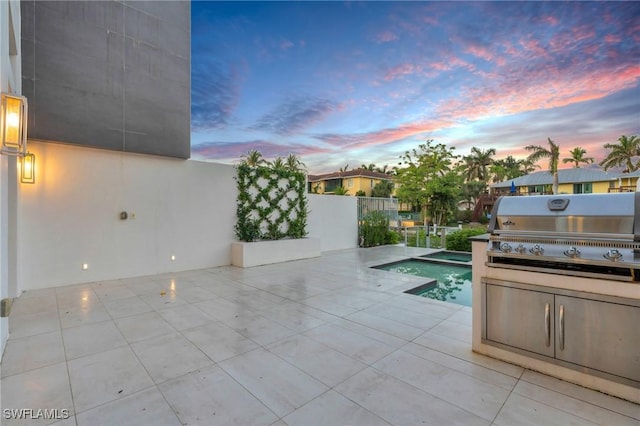 patio terrace at dusk featuring a fenced in pool and a grill