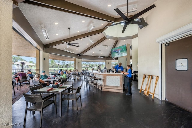 dining area with beam ceiling, ceiling fan, high vaulted ceiling, and a textured ceiling