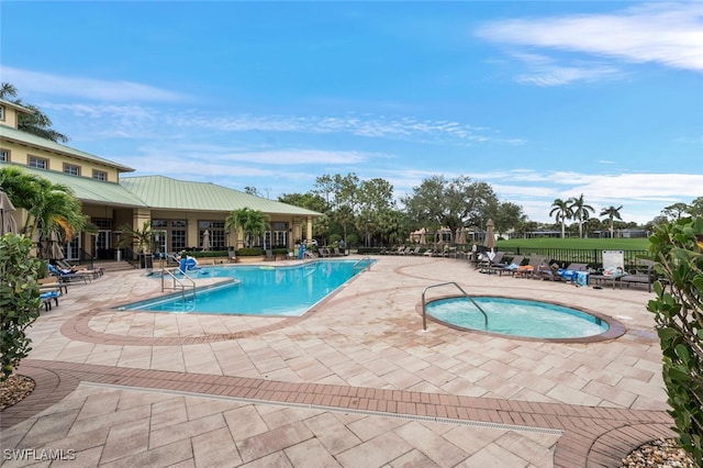 view of pool with a patio and a hot tub