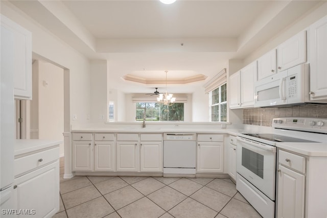 kitchen featuring a tray ceiling, light tile patterned floors, white cabinets, and white appliances