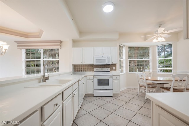 kitchen featuring white appliances, white cabinets, sink, ceiling fan, and light tile patterned floors
