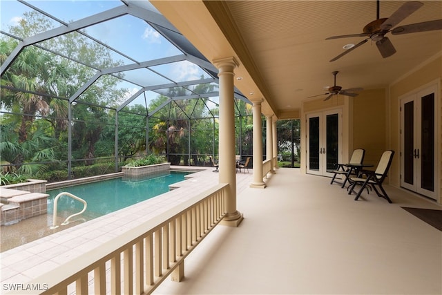 view of pool with glass enclosure, ceiling fan, a patio area, and french doors