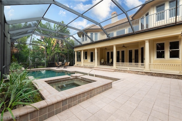 view of swimming pool featuring glass enclosure, ceiling fan, french doors, an in ground hot tub, and a patio