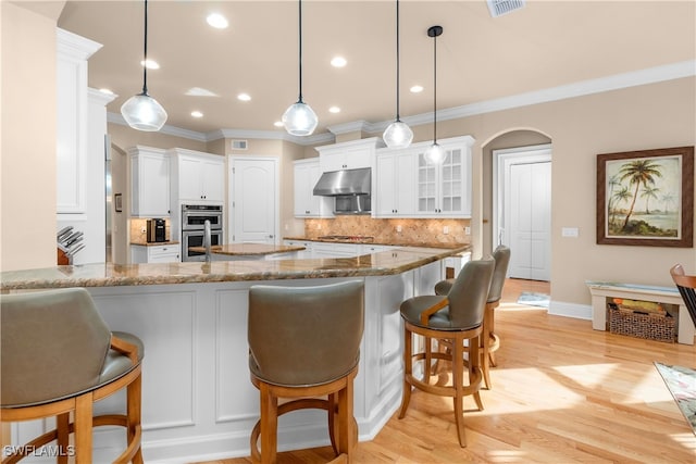 kitchen with white cabinets, pendant lighting, light stone countertops, and tasteful backsplash