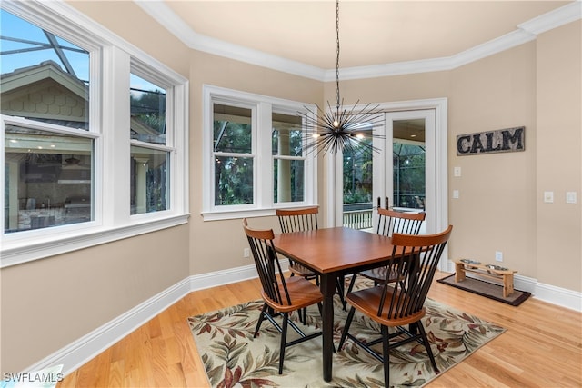 dining area featuring a chandelier, hardwood / wood-style floors, french doors, and crown molding