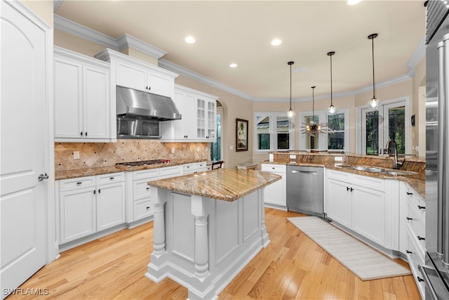 kitchen with kitchen peninsula, tasteful backsplash, stainless steel appliances, pendant lighting, and white cabinetry