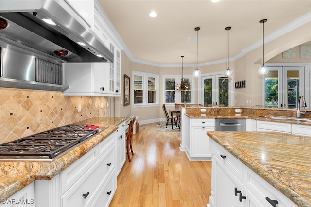 kitchen featuring decorative backsplash, french doors, ventilation hood, stainless steel gas cooktop, and white cabinetry