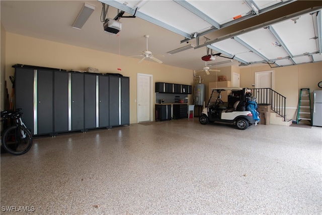 garage featuring refrigerator, a garage door opener, ceiling fan, and water heater