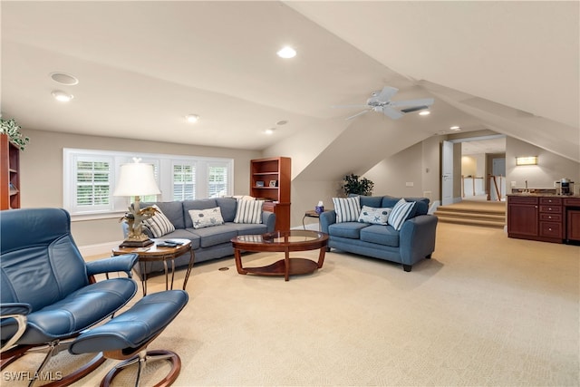 living room featuring ceiling fan, light colored carpet, and vaulted ceiling