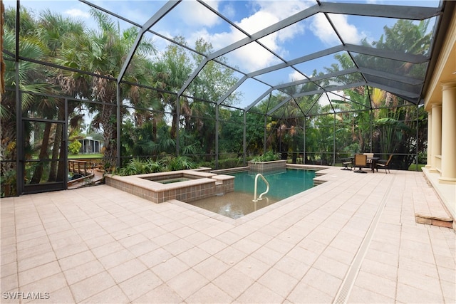 view of swimming pool with an in ground hot tub, glass enclosure, and a patio area