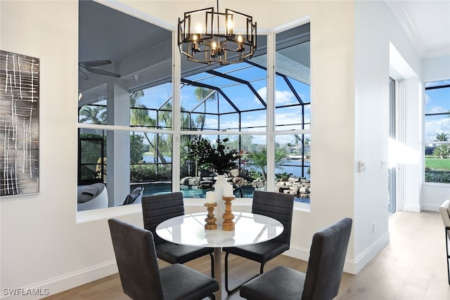 dining room with hardwood / wood-style floors, an inviting chandelier, a healthy amount of sunlight, and ornamental molding