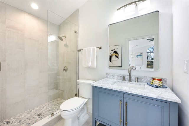 bathroom featuring tiled shower, vanity, and toilet