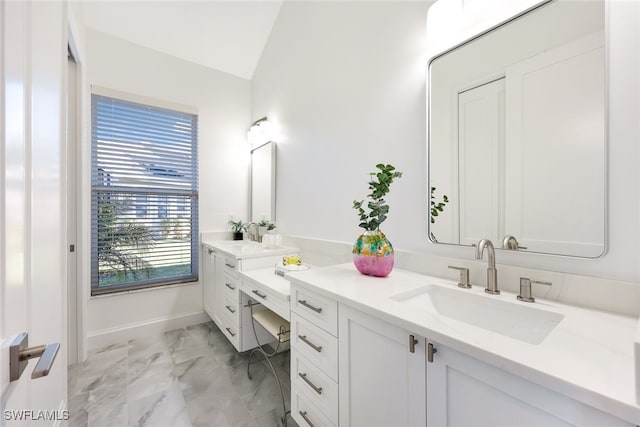 bathroom with vanity, a healthy amount of sunlight, and lofted ceiling