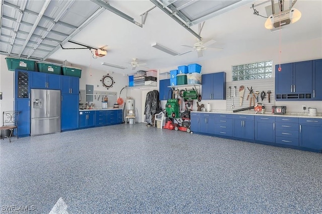 garage featuring electric panel, stainless steel fridge with ice dispenser, ceiling fan, and a garage door opener