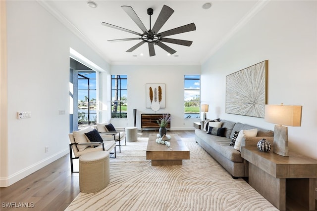 living room with light wood-type flooring, ceiling fan, and ornamental molding