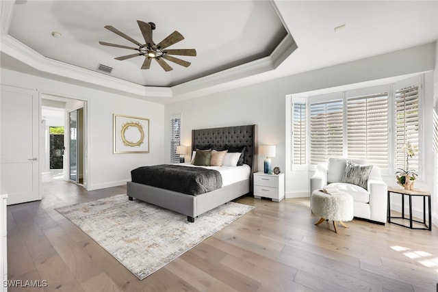 bedroom featuring a tray ceiling, multiple windows, and ceiling fan