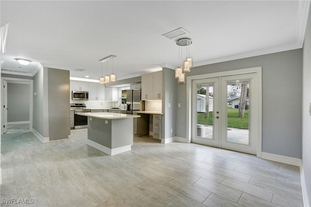 kitchen featuring a center island, backsplash, french doors, decorative light fixtures, and stainless steel appliances